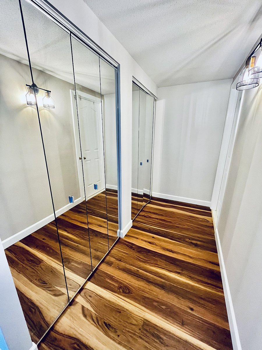 Large mirrored closets provide abundant storage and create a bright, polished dressing area.