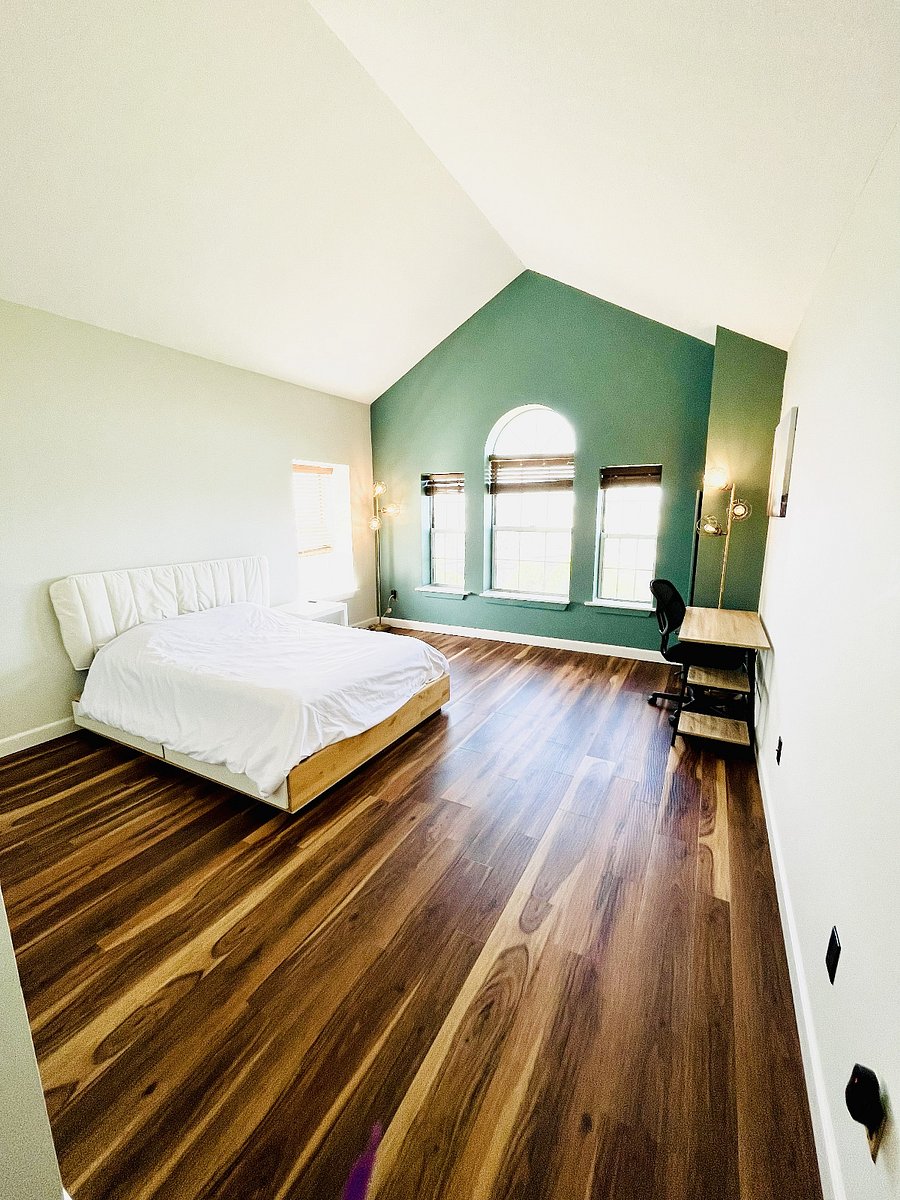Spacious furnished bedroom with cathedral ceilings, a dedicated work area, abundant natural light, and room to unwind.