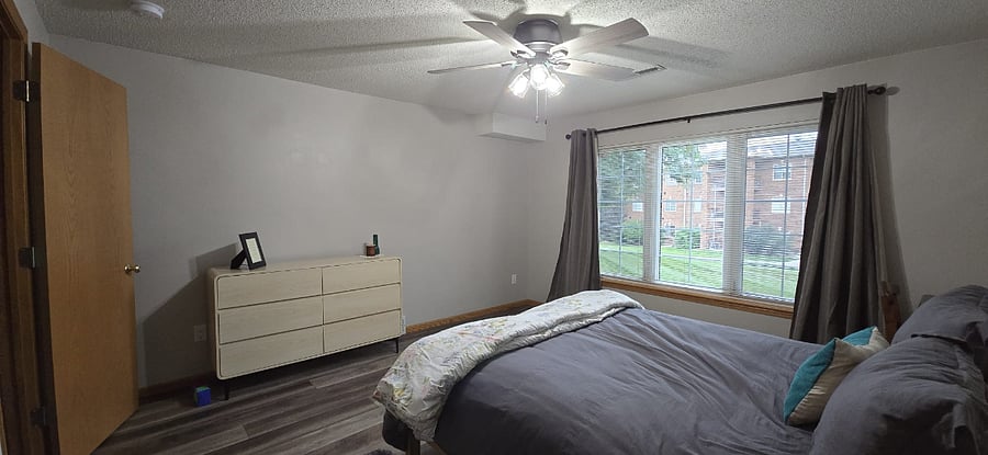 Bedroom with full dresser, nightstand, lamp, desk/chair, and blackout curtains