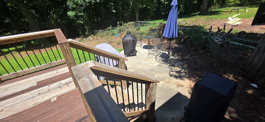 Small concrete patio to house the grills and sitting area. Neighbors house is being fixed and will have that area cleaned up 
