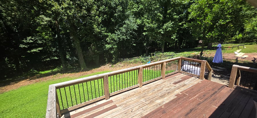 Large deck with optional charcoal grills out back, table with seating, not pictured is a portable hammock, tiki torches, outdoor lights for night, and bug zapper