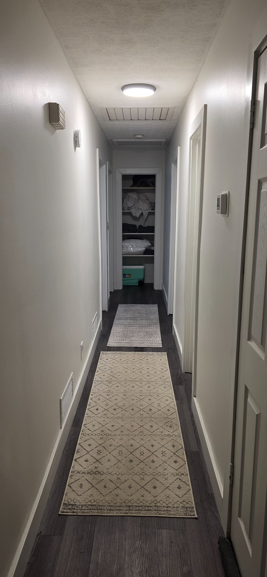Main hallway with bedrooms, two guest beds are on the left side, additional dedicated storage shelves in the hallway for each room, hall light on motion sense. 