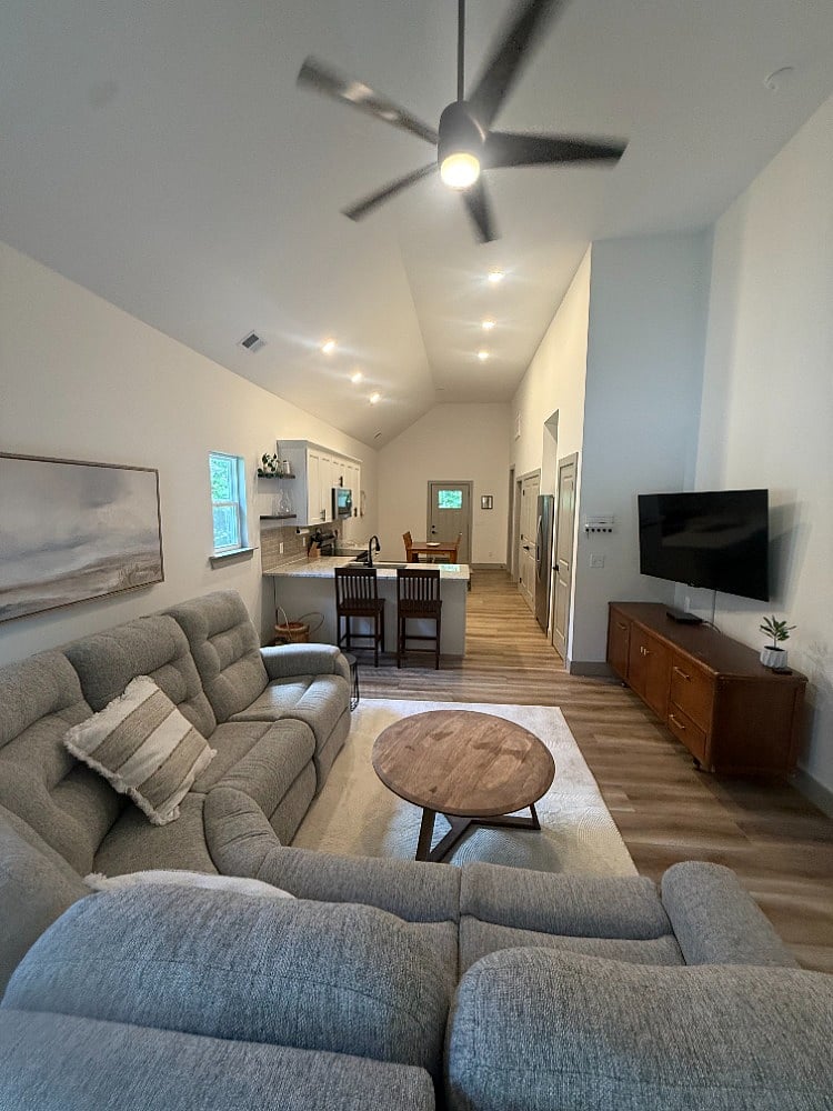 This is taken from the front entrance door. The shared living space of living room, kitchen, and dining room has vaulted ceilings and great natural light. 