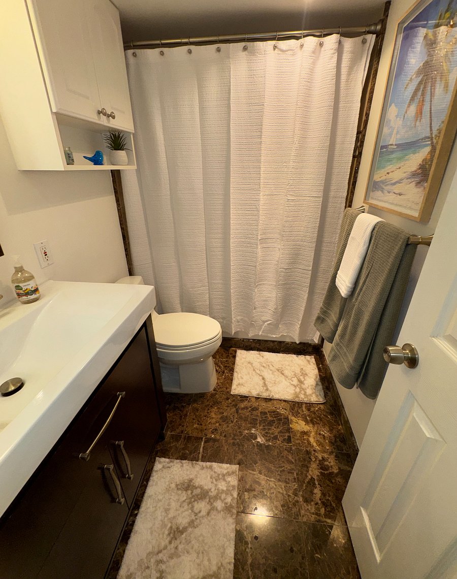 Bright, updated bath featuring a modern vanity, full tub/shower, plush towels, and everything you need for a comfortable extended stay.