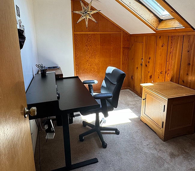 The office includes a sit/stand adjustable desk and ergonomic office chair. 