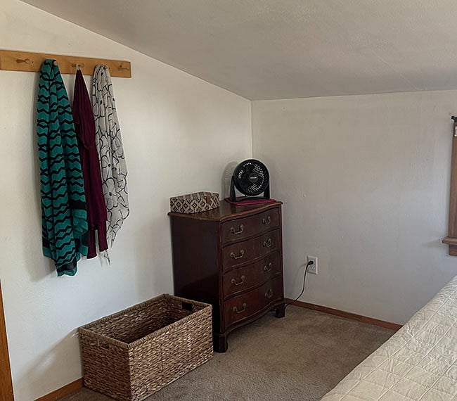 Small dresser and peg board in bedroom