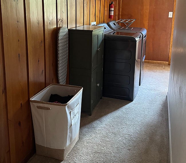 Full-size washer and dryer, as well as iron and small ironing board and drying rack.