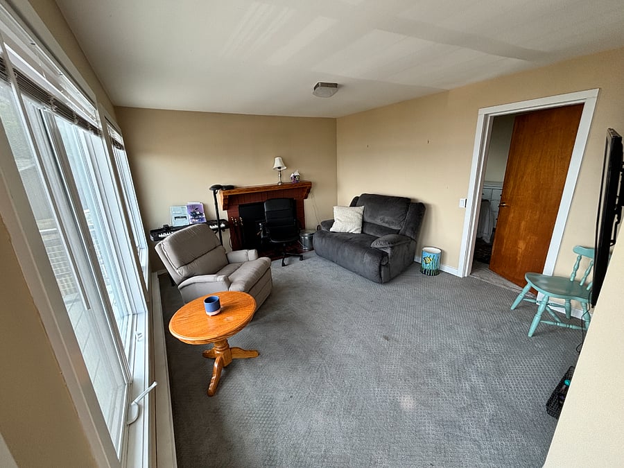 Rec room, with recliners, view windows and 55 inch TV.  Door leads to bedroom.  