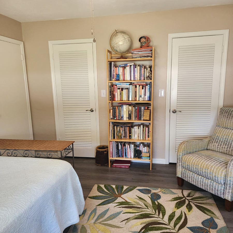 bedroom closet, corner recliner chair, & books on bookshelf (books are property of the house but may be used)