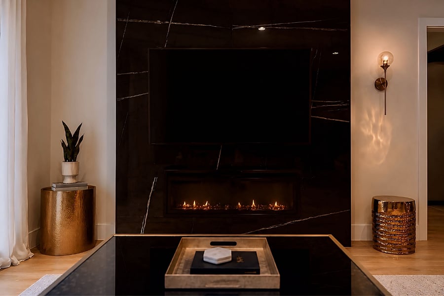 Designer black quartz media wall with a linear fireplace, 65 Smart TV, and warm ambient lighting