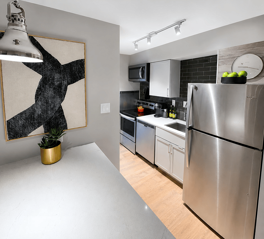 Fully equipped chefs kitchen featuring Whirlpool Suite appliances, tiled backsplash, spacious quartz counters, and a full pantry - perfect for cooking and entertaining