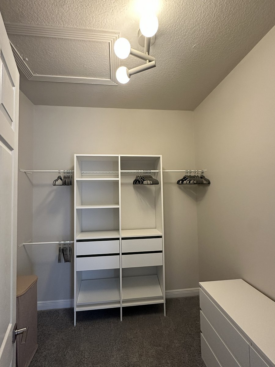 Walk-in Closet (Primary Bedroom) with a multi-storage/hanging unit, a six-drawer dresser and two laundry baskets