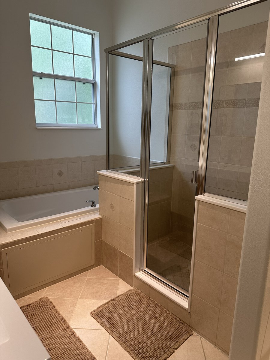 Primary bathroom with dual-sink vanity, walk-in shower, jacuzzi tub, and linen closet