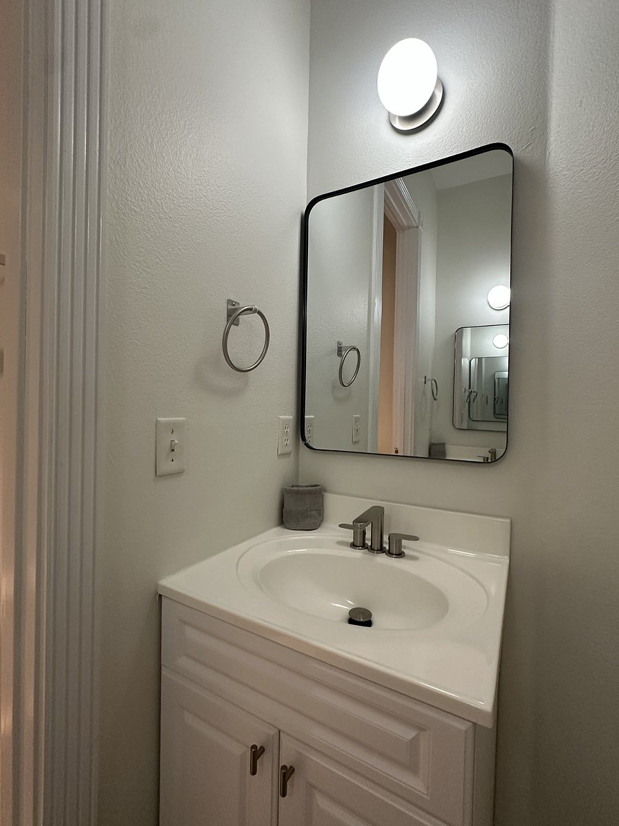 Guest bathroom with two separate single-sink vanities and a jacuzzi tub/shower combination