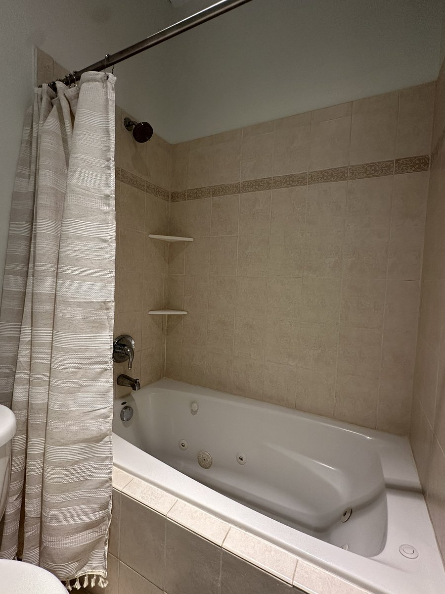 Guest bathroom with two separate single-sink vanities and a jacuzzi tub/shower combination
