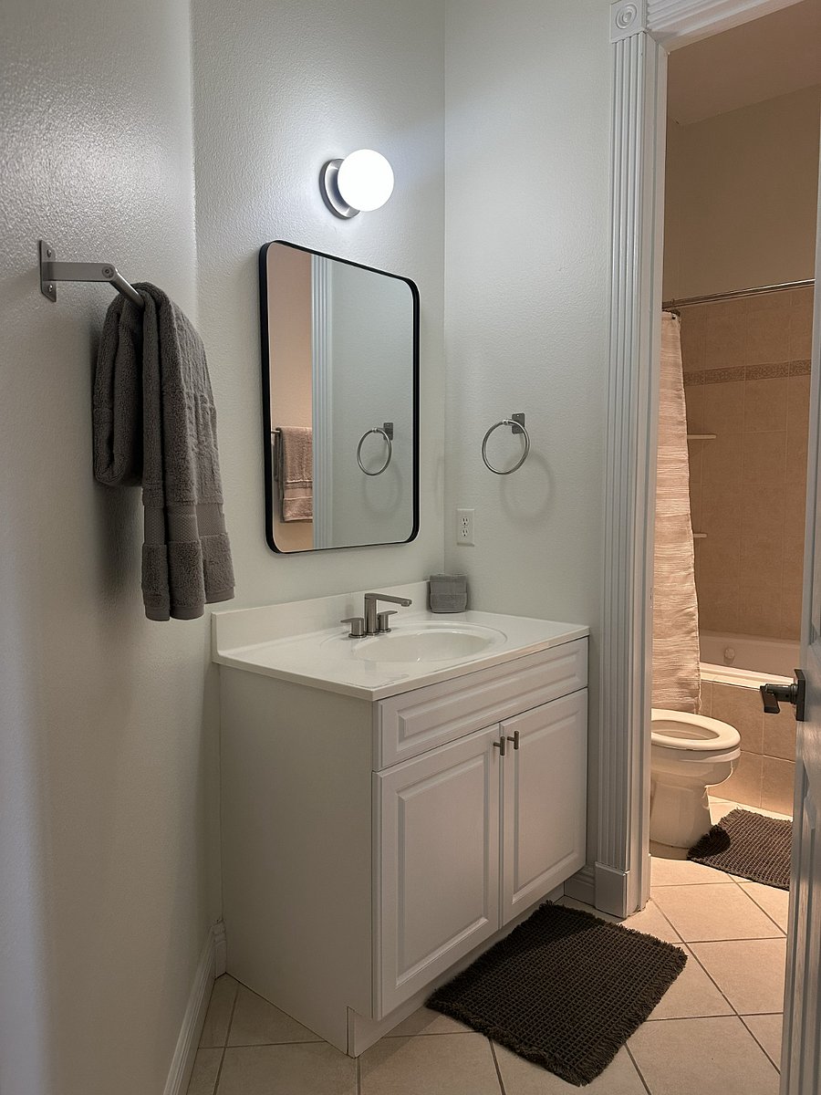 Guest bathroom with two separate single-sink vanities and a jacuzzi tub/shower combination