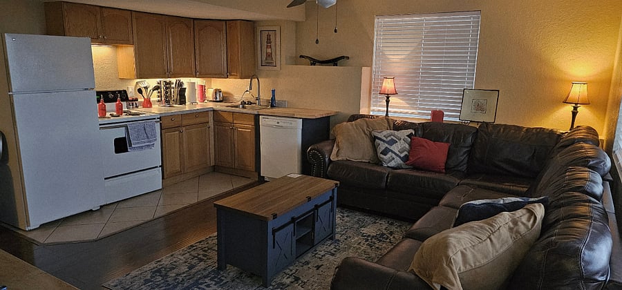 Front room and kitchen, full size fridge, stove, oven, and dishwasher. Couch seats 6 people. 
