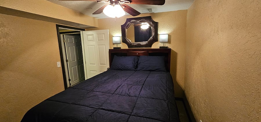 Third bedroom with queen size bed. The bed has dresser drawers built into the bed frame. Full size closet with plenty of hangar and shelving space. Ceiling fan.