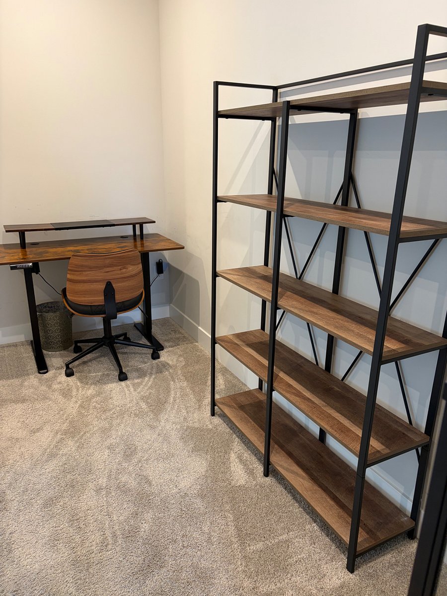 Loft area study with bookshelves and a glass cabinet