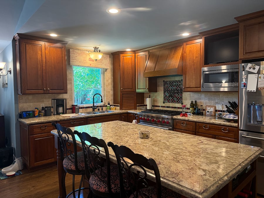 Kitchen with island and 3 chairs. Microwave, pot filler, inline water line attached to coffee maker, dishwasher,