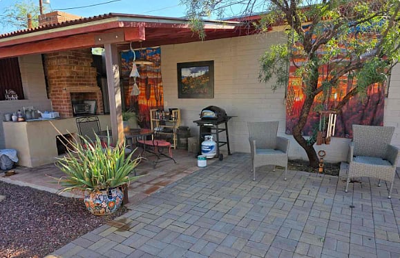 Very Cool covered outdoor kitchen and grill area. Cabinet contains pots and pans and a single pot burner, portable convection cooker, toaster oven.