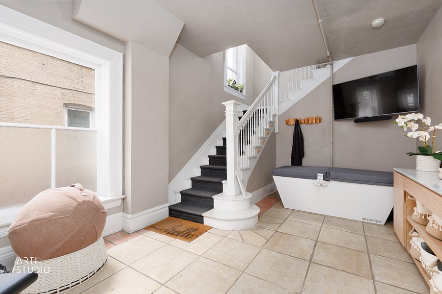 The shared lobby features the cold plunge and a marble-top entry table, with a TV on hand if you want to follow workout videos. Deliveries get their own door code, so Amazon and couriers can drop packages securely in the lobby while your private entrance stays on a separate code.