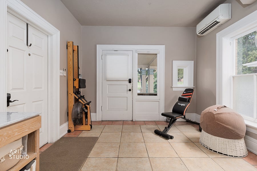 A shared workout area with stack weights, a water rower, a bench, and a yoga ball, so you can train in the building without a gym membership.