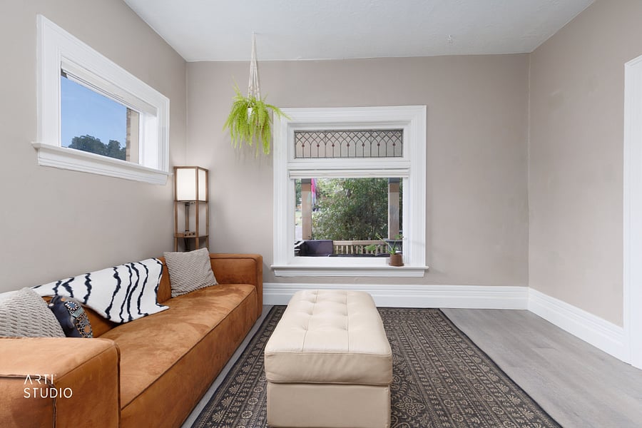The home's original stained glass window, a standout historic detail that casts warm light across the living space.
