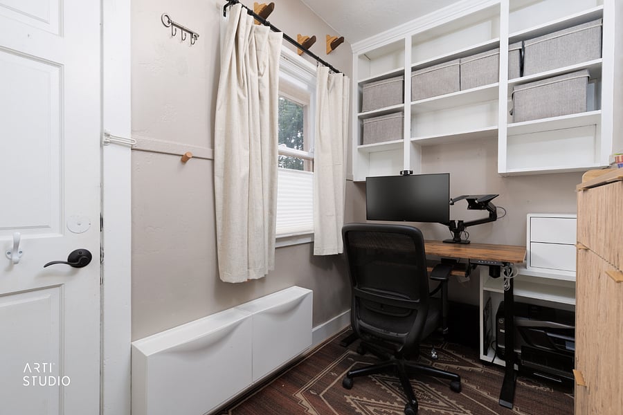 A dedicated home office with a programmable electric standing desk, ergonomic chair, and built-in shelving above the desk. It doubles as a gear station: storage for hats, gloves, and shoes, hooks for coats, bags, and helmets, and overhead racks for up to four sets of skis or snowboards (not pictured).