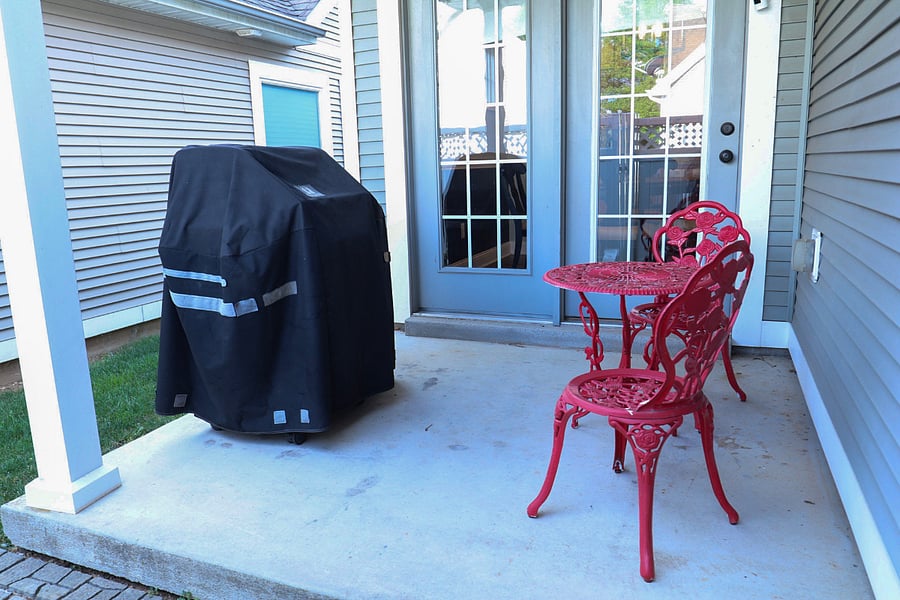Back porch with small fenced in backyard, grill and seating