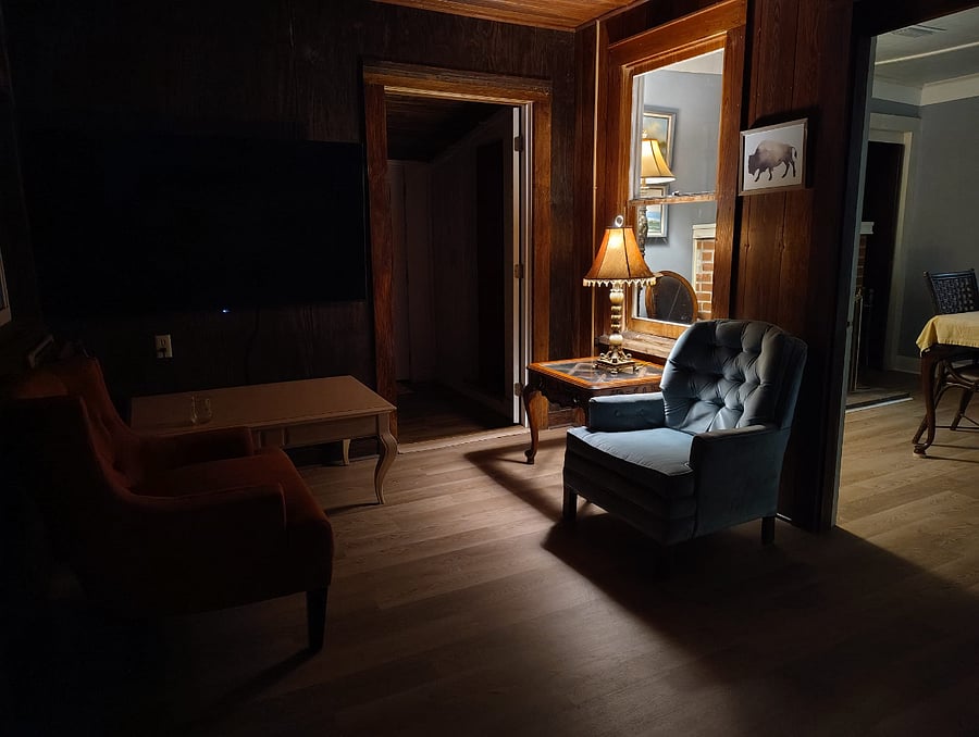 As evening settles in, a warm pool of lamplight creates a quiet corner for reading, conversation, or simply unwinding. Nearby, the signature bison makes another subtle appearancebringing strength, character, and a familiar sense of identity to The Prospect Retreat.