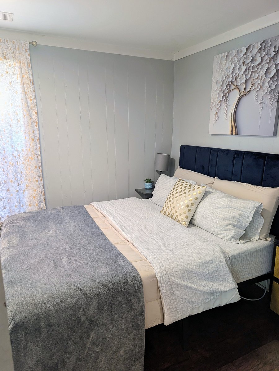 Main Bedroom Queen Bed. Small TV. Dresser. Side Table. Closet. 2 Windows.