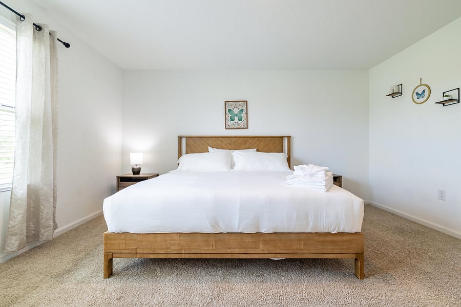 Spacious master bedroom with large windows and attached full bathroom.