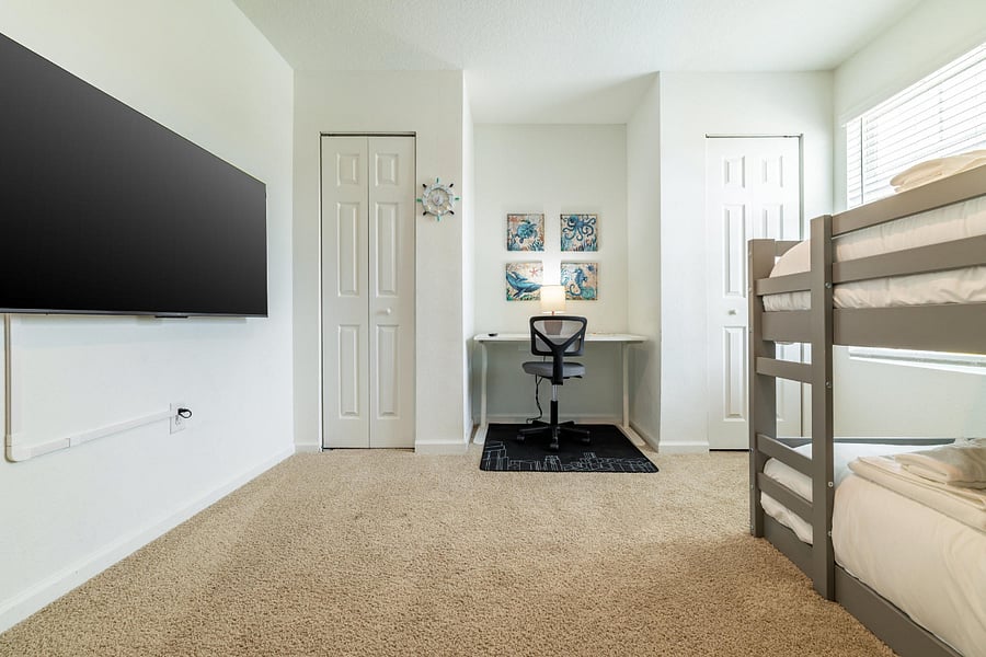 Fun bunk room with workspace and TV.