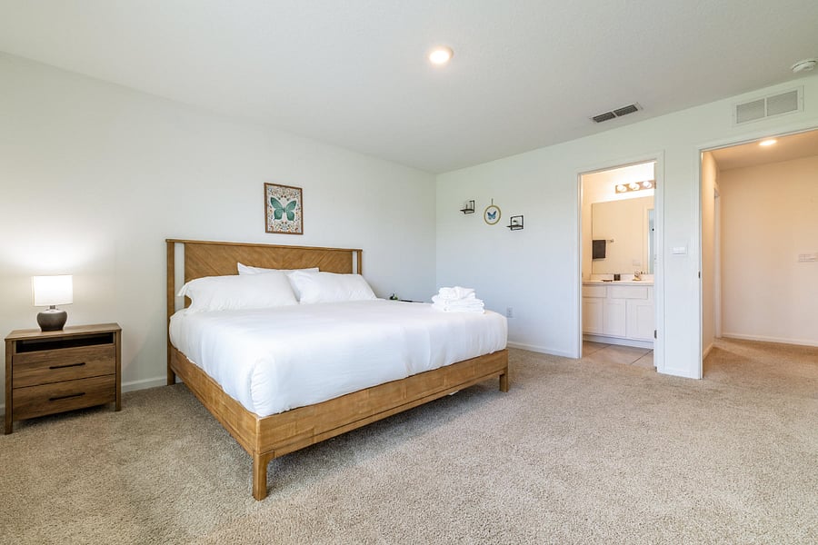 Spacious master bedroom with large windows and attached full bathroom.
