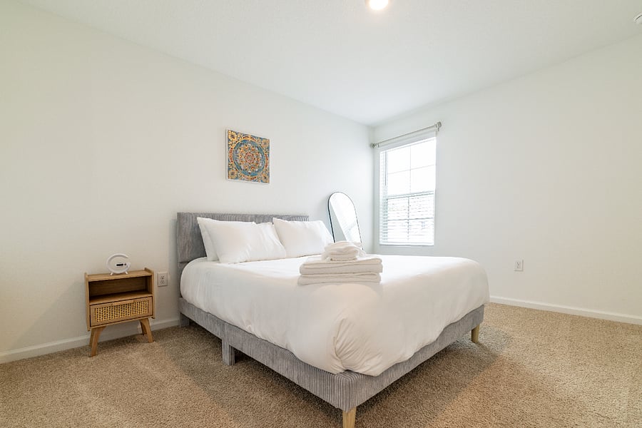 Cozy queen bedroom with natural light.