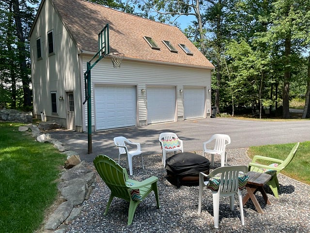At the end of the driveway between the entrance and the grassy yard there is a fire pit.