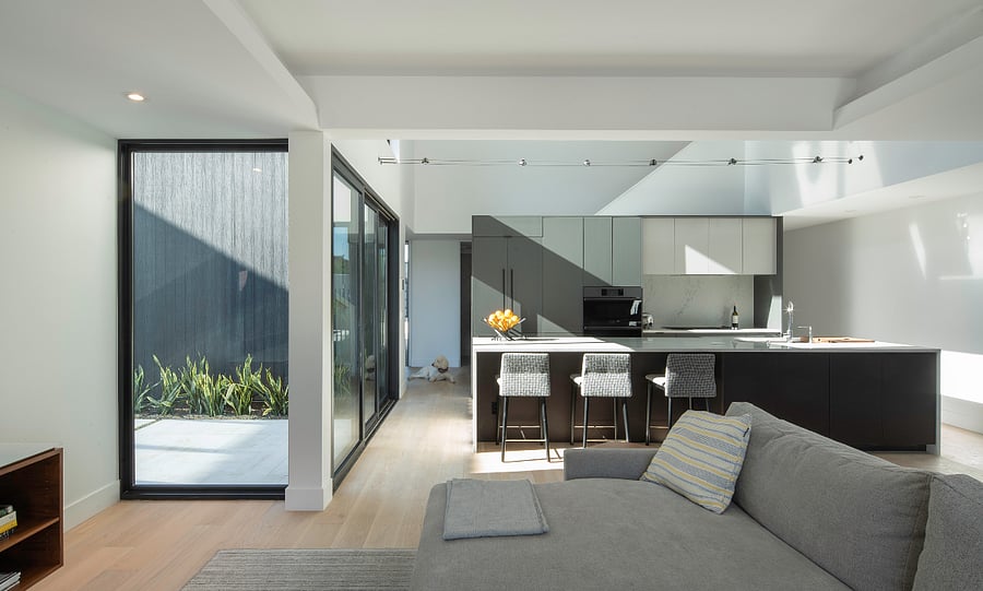 Living Room / Kitchen View: The main living space blends premium finishes, generous natural light, and easy pool access for a turnkey executive rental experience.