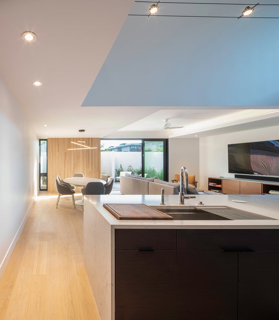 Kitchen / Living Volume: Natural light, clean architectural lines, warm flooring, and open sightlines create a refined modern living environment that feels both elevated and comfortable.