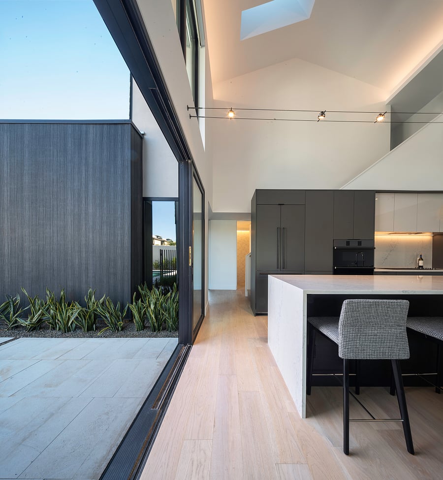 Kitchen / Indoor-Outdoor Connection: Expansive glass openings connect the kitchen and living spaces to private outdoor courtyards, creating effortless indoor/outdoor Phoenix living.