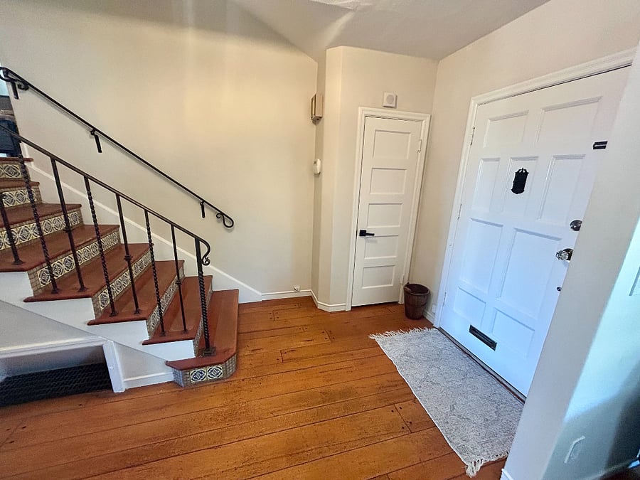 Entry door with closet space and staircase to room.