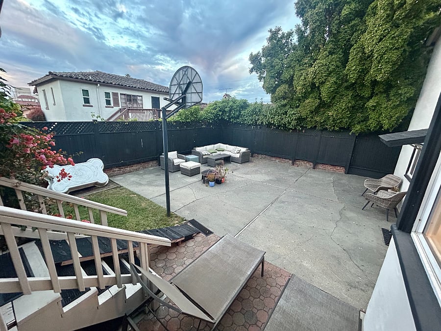 Outdoor space with grass, fruit trees, patio furniture, and privacy.