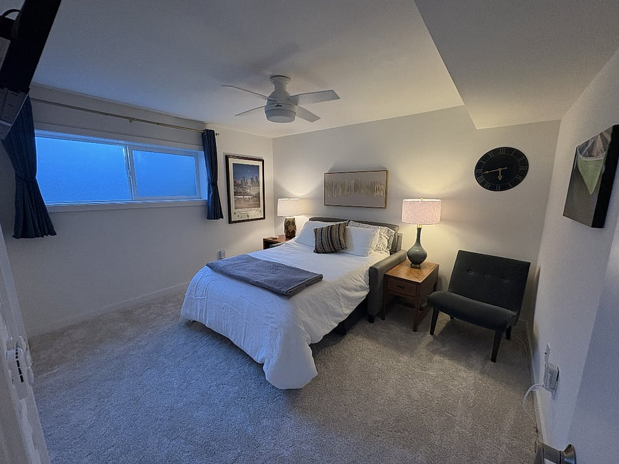 The bedroom features a remote-controlled ceiling fan/light and comfortable furnishings designed for an extended stay.