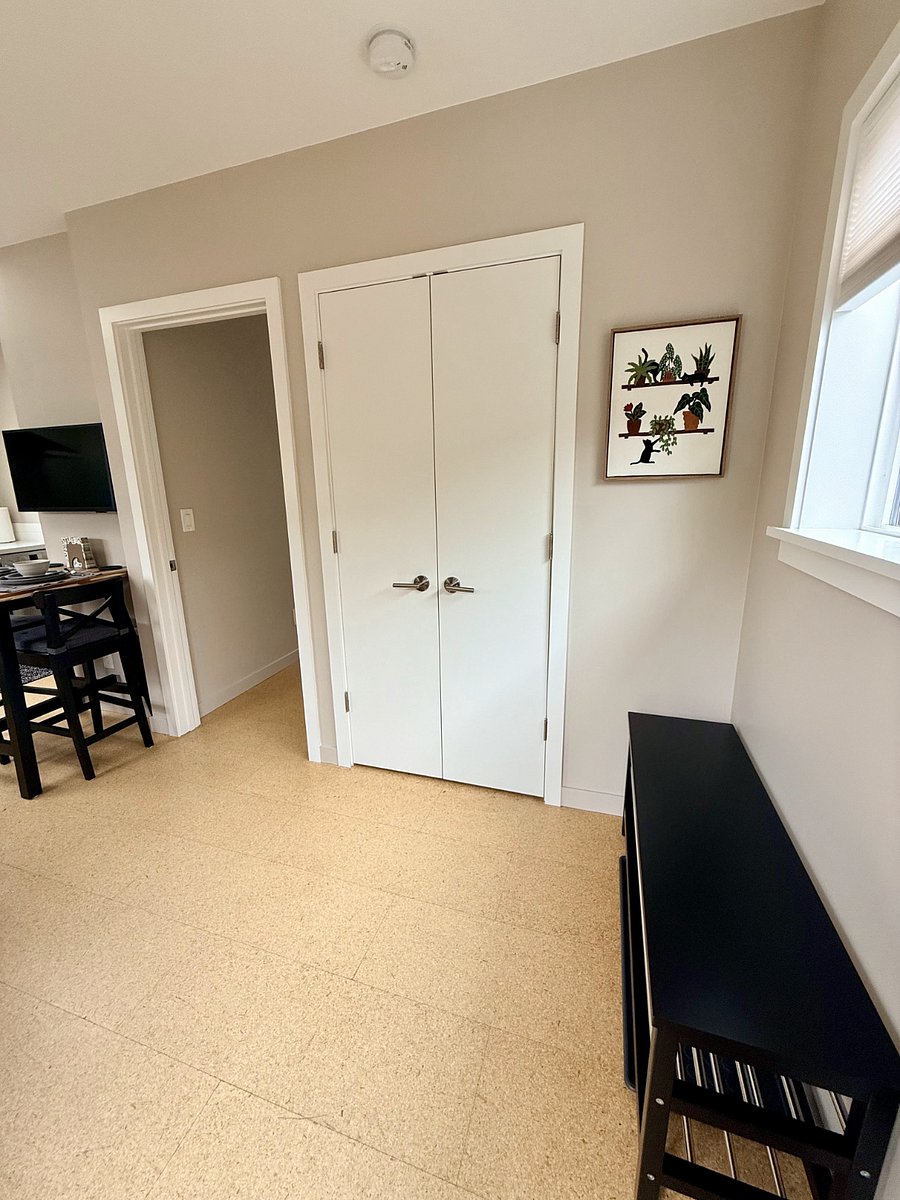Storage closet in entryway, next to shoe bench.