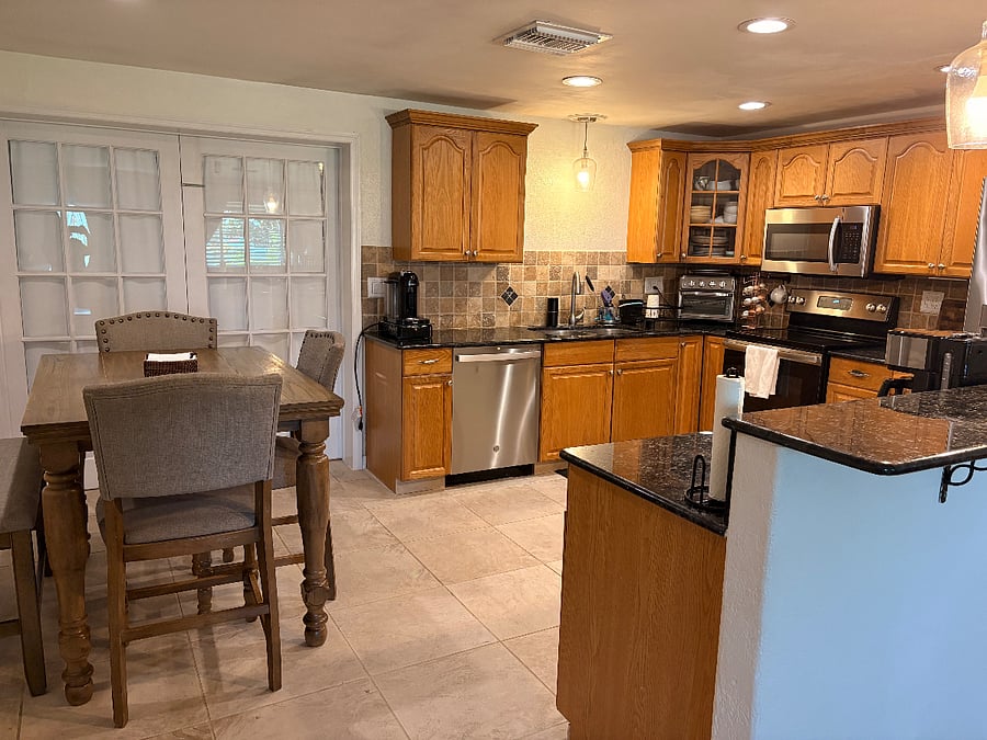Large kitchen with granite countertop and solid cabinets. Air fryer, Nespresso and regular drip coffee machine. Dinette with bench that seats 5. Double French doors lead to second living room/office space.