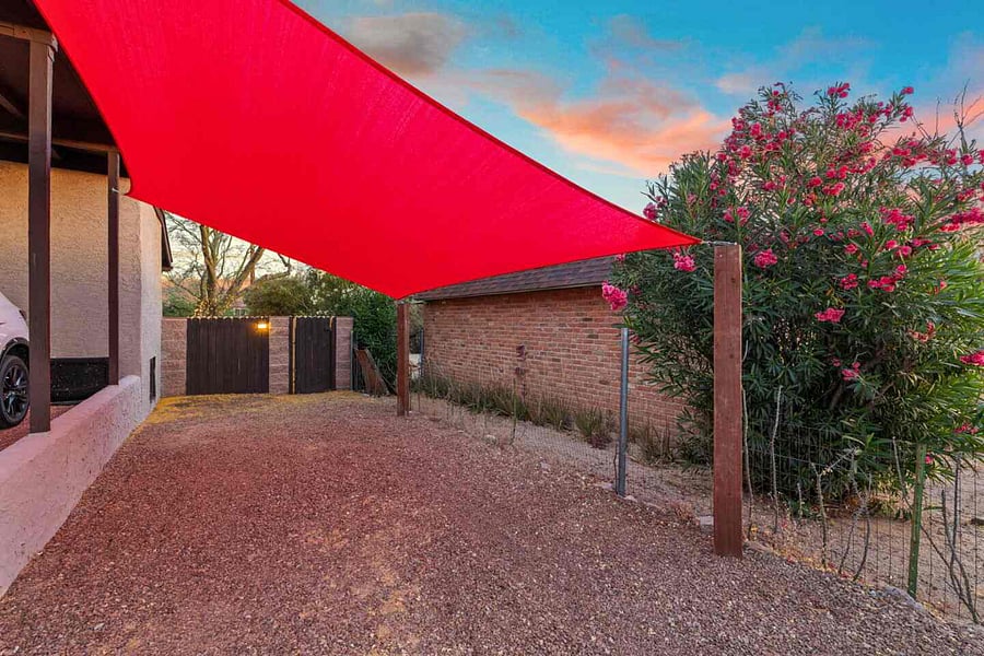 Free parking space under red shade sail (with entryway through gate door behind)