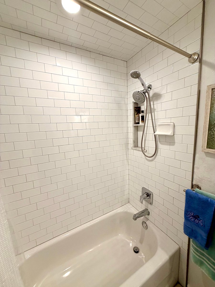 Lovely bright white subway tile in shower, including ceiling!
