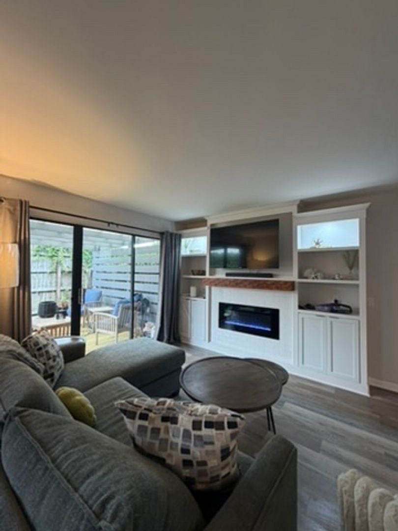 Living with built-in entertainment system and electric fireplace. Provides inviting ambiance and warmth if needed.