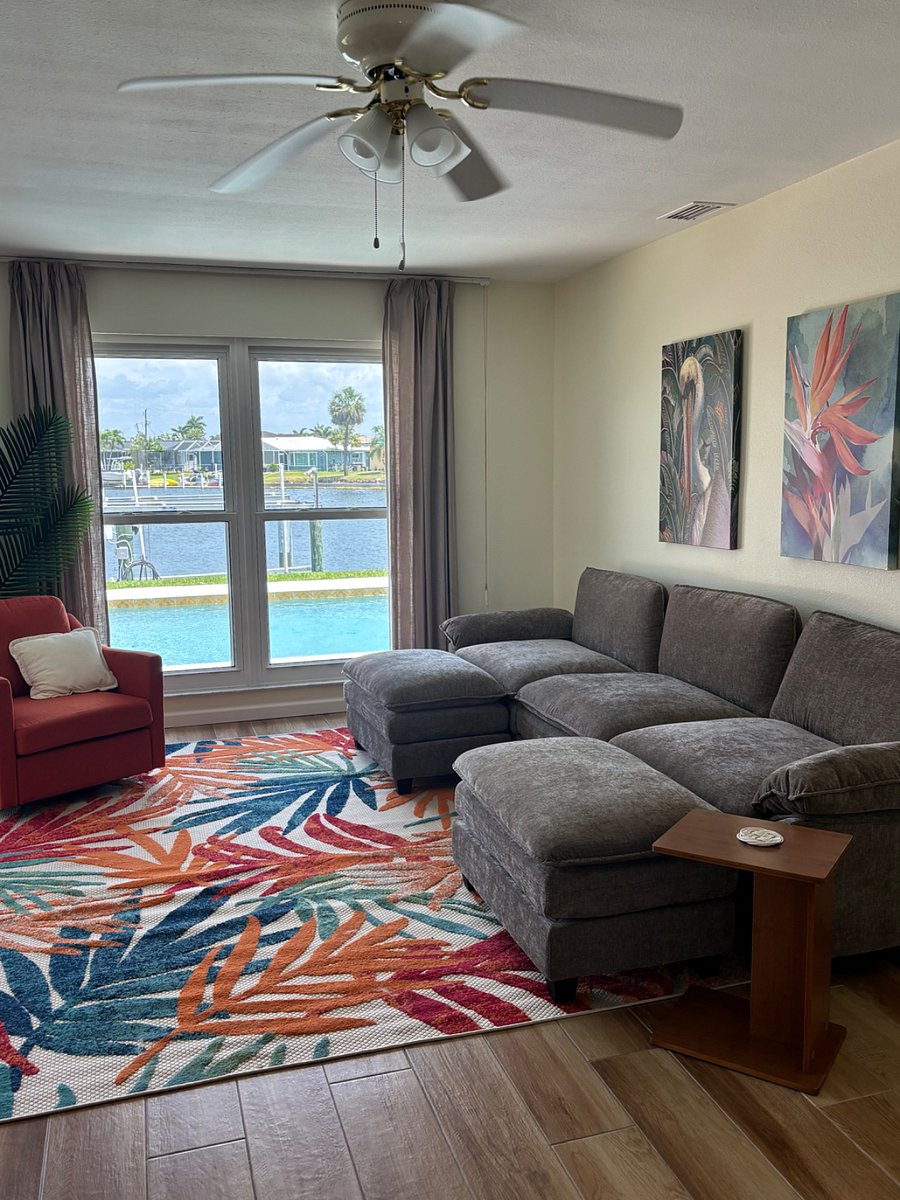 Livingroom with Large sofa and smart TV right off of the kitchen and Lanai