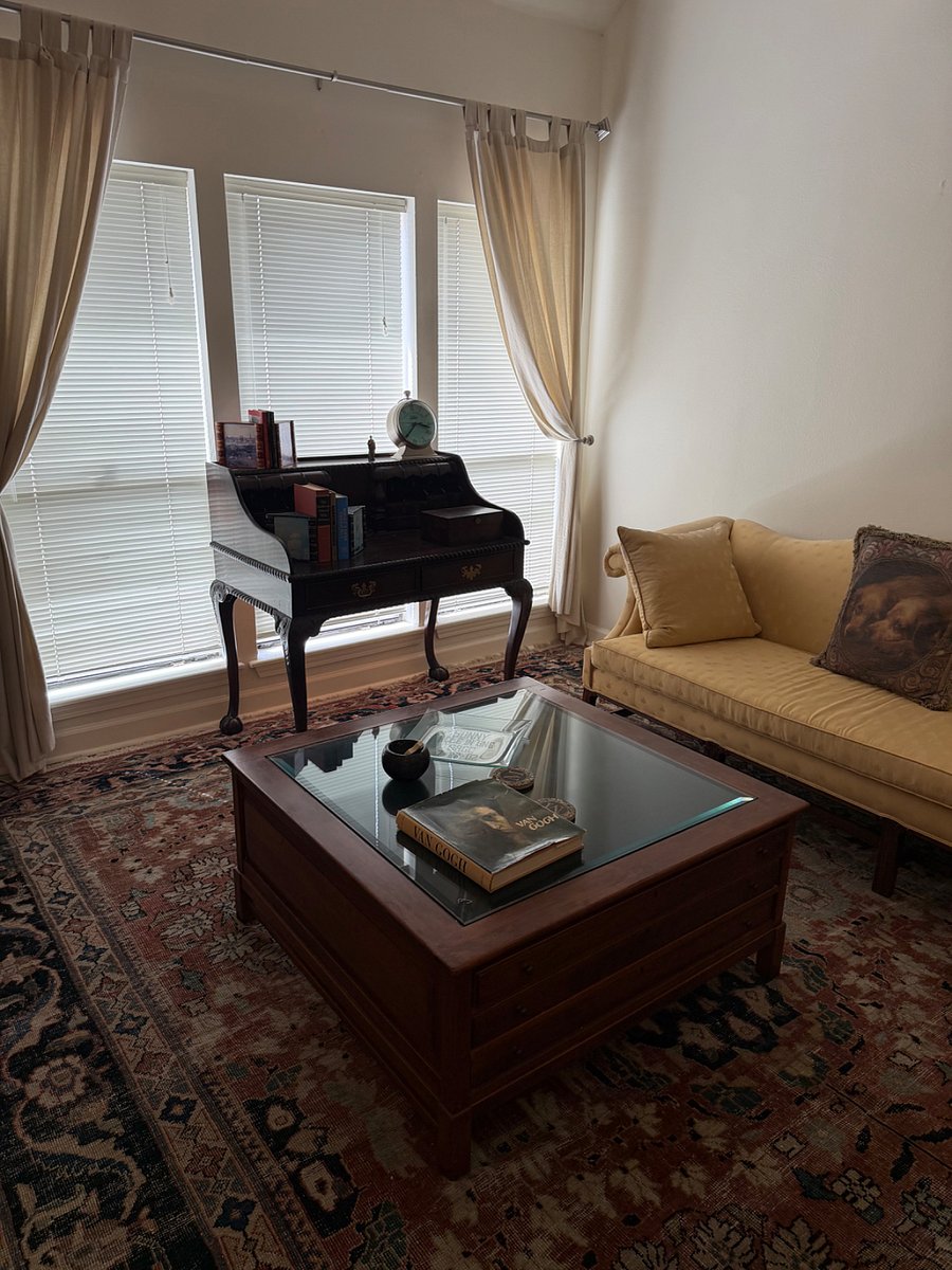 Living room with desk overlooking patio. 
Vaulted ceilings, fireplace, ceiling fan. 